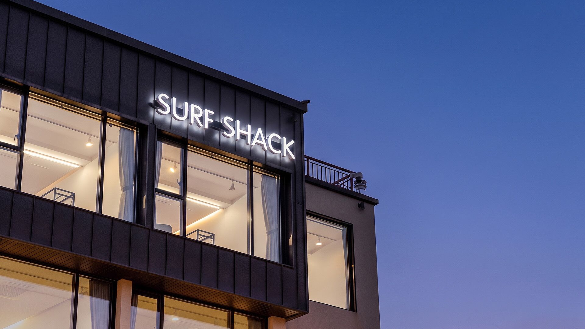 Ein Gebäude mit einem Schild, das 'SURF SHACK' zeigt und einen Surf-Zusammenhang kennzeichnet.