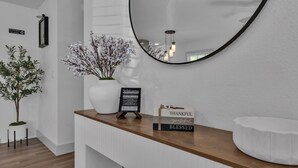 En receptionsdisk med en vit vas med blommor, en välkomstskylt och en skylt med texten ”TACKSAM, LYCKLIG, VÄLSIGNAD”.