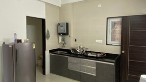 A kitchen with a refrigerator, stove, and sink.