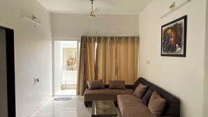 A spacious living room with a large sectional sofa, a coffee table, and a ceiling fan.