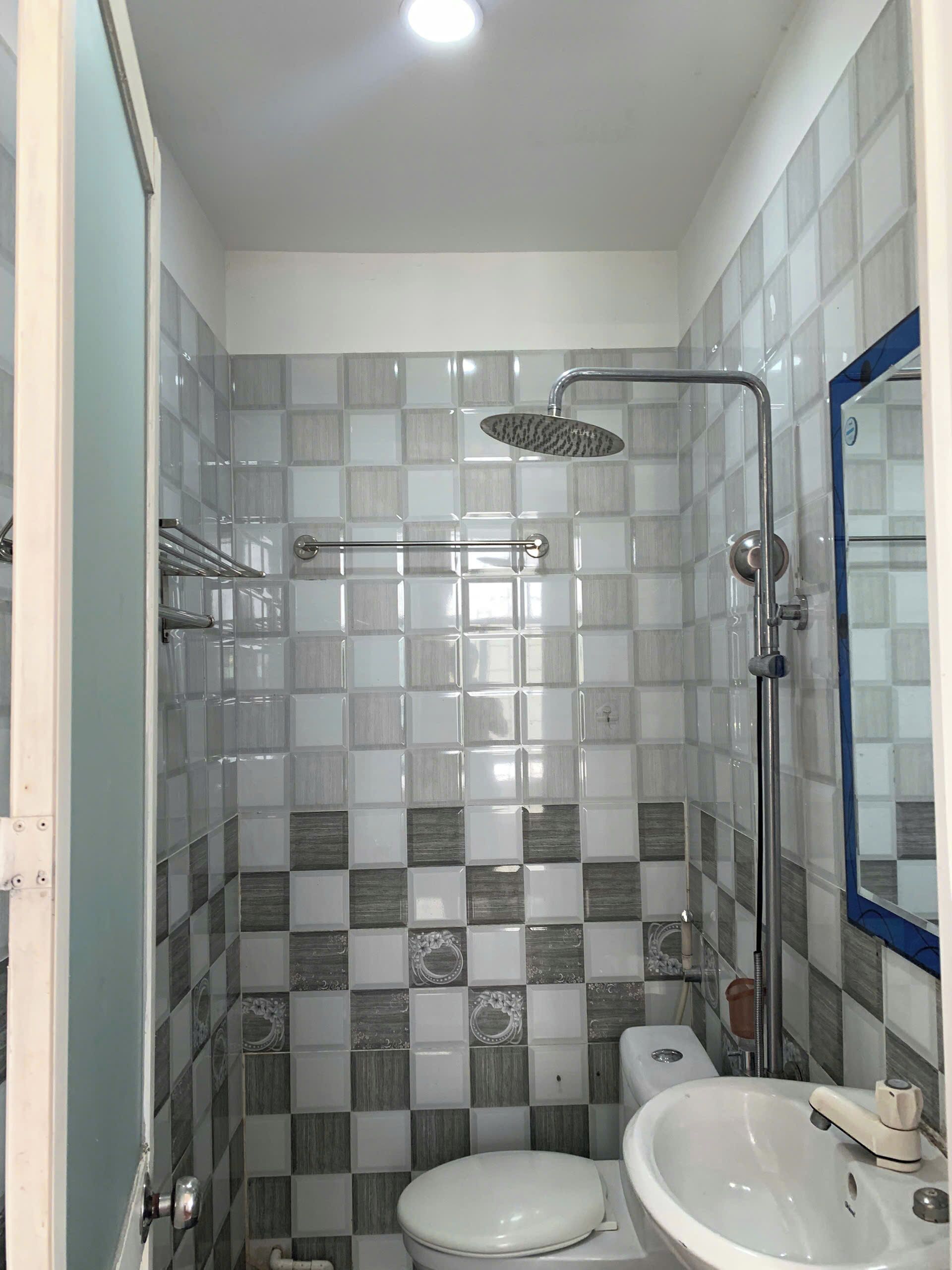 A bathroom with a shower, toilet, and sink.