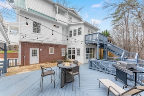 Eine Terrasse mit Feuerstelle, Gartenmöbeln und Grill.