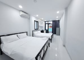 Une chambre d’hôtel avec deux lits, une fenêtre, un appareil de climatisation et une vue sur l’extérieur.