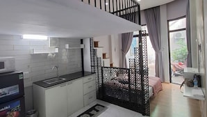 Eine moderne Küche mit Schwarz-Weiß-Farbgebung, einer eingebauten Mikrowelle und einem Spülbecken.