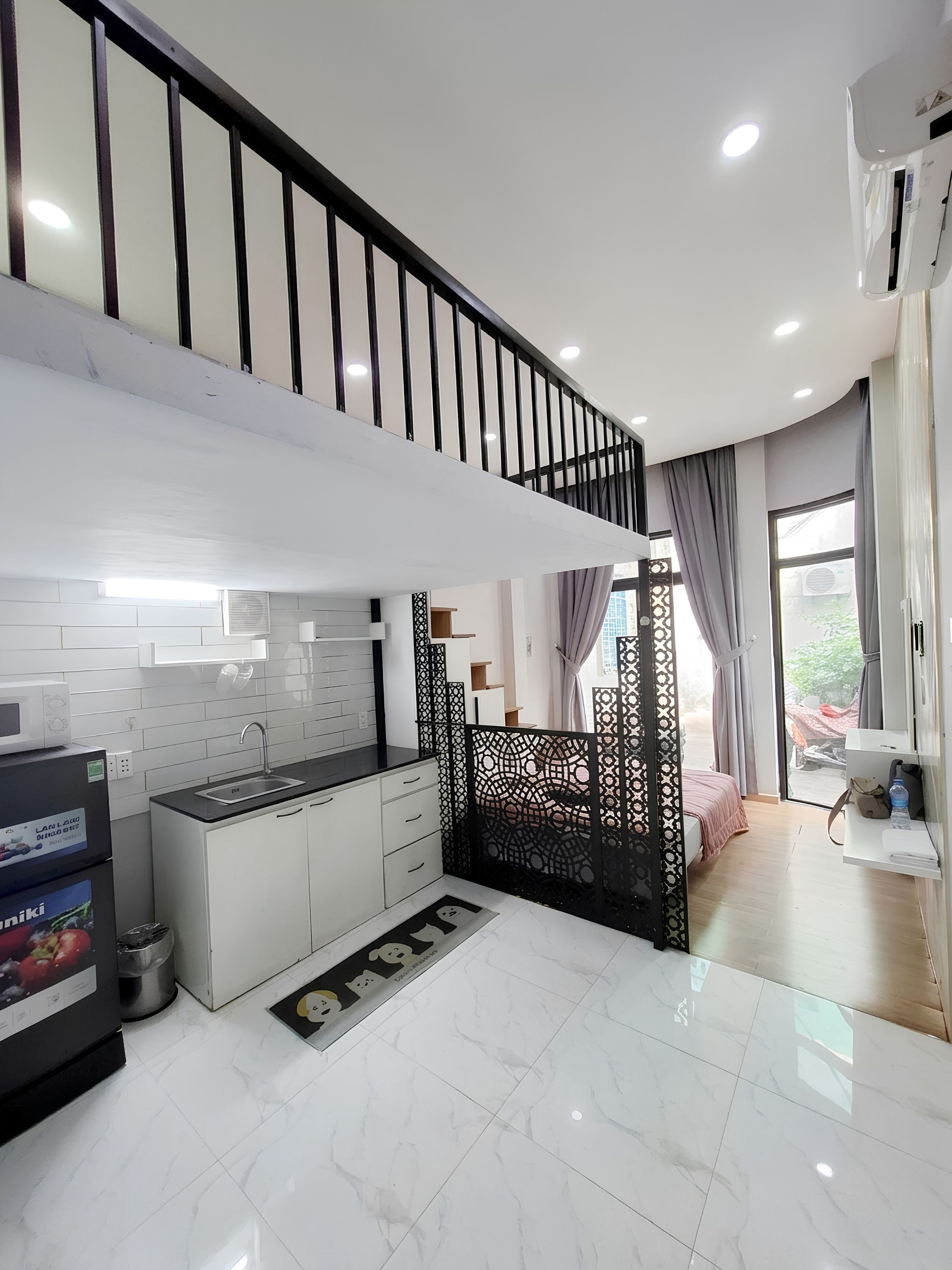 Una cocina moderna con armarios blancos, una encimera negra y un lavabo de acero inoxidable.