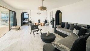 Uma sala de estar moderna com sofá, cadeiras e área de jantar.
