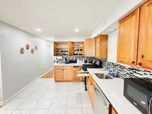 Una cocina moderna con armarios de madera, una isla central y un horno empotrado.