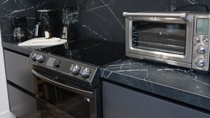 A modern kitchen with a built-in microwave, toaster oven, and stainless steel appliances. - Modern 1 bedroom apartment in Glendale near The Americana at Brand (Glendale)