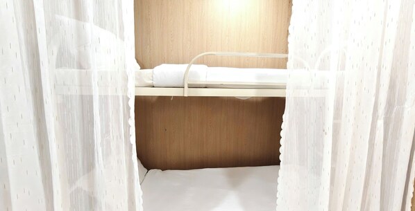 A bunk bed with a wooden headboard and white bedding. - Lunaria Maison- Lucy House (Ho Chi Minh City)