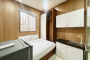 A bedroom with a bed, a desk, a wardrobe, and a bathroom with a sink. - Lunaria Maison- Lucy House (Ho Chi Minh City)