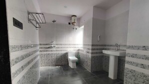Une salle de bain avec des toilettes, un lavabo et une douche.