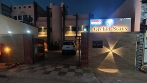 L’entrée d’Orchid Stays est signalée par un panneau indiquant que des chambres sont disponibles.