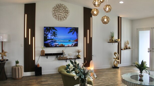 Un salon moderne doté d’un téléviseur à écran plat, d’un éclairage décoratif et d’un coin salon confortable.