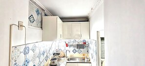 A small kitchen with white cabinets, a tiled backsplash, and a sink. - Lunaria Maison Japan Town Kitchen Suite (Ho Chi Minh City)
