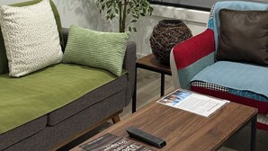 A living room with a sofa, a coffee table, a plant, and a window with blinds. - Slice of Heaven - Near Spruce Meadows - 2 Car Garage Central AC avail -Sleeps 8  (Calgary)