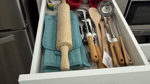 A kitchen drawer with a fire blanket, measuring tools, and wooden utensils. - Slice of Heaven - Near Spruce Meadows - 2 Car Garage Central AC avail -Sleeps 8  (Calgary)