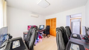 Un espace de bureau moderne doté de plusieurs postes de travail informatiques, de chaises ergonomiques et d’une porte en bois.