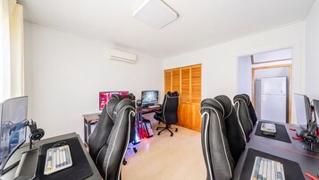 Un espacio de oficina moderno con varias estaciones de trabajo de computadora, sillas ergonómicas y una puerta de madera.