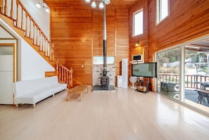 A wooden interior with a sofa, a fireplace, a TV, and a balcony. - Yangpyeong Narinsoom Private Villa (Yangpyeong)