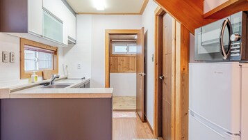 Una cocina compacta con una isla central, armarios de madera y un microondas integrado.