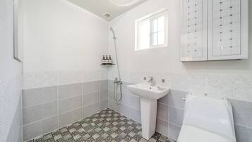 A bathroom with a shower, sink, and toilet.