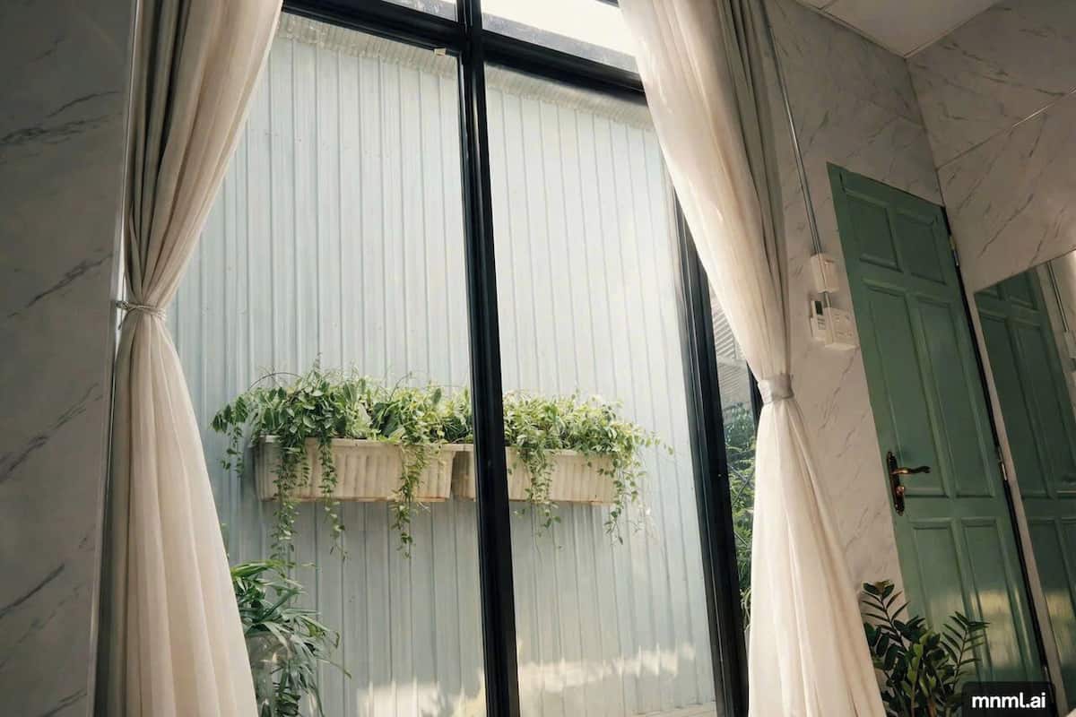Une pièce avec une grande fenêtre, des rideaux et une porte verte.