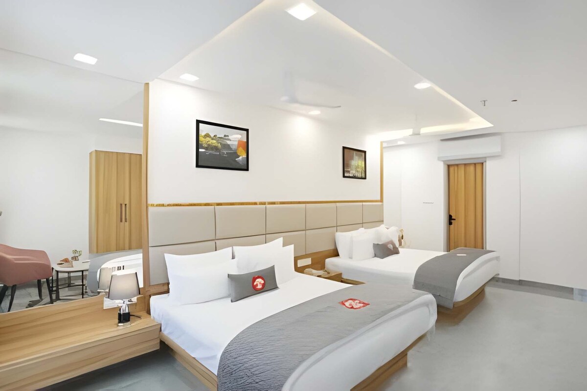 Une chambre d’hôtel moderne avec deux lits, un bureau et une armoire.