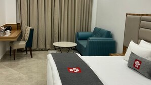 A hotel room with a bed, a desk, a chair, a small table, and a sofa. - Mastiff Select Aparajita (Danta Ramgarh)