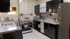 Una cocina moderna con estufa a gas, horno, microondas y armarios negros.
