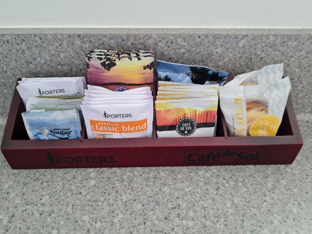 A box containing various coffee blends and a bag of pastries.