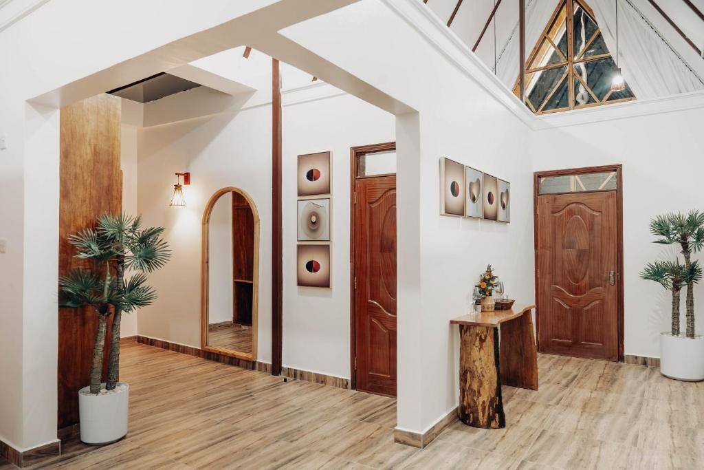 A spacious hallway with wooden flooring, a wooden archway, and a ceiling with skylights.