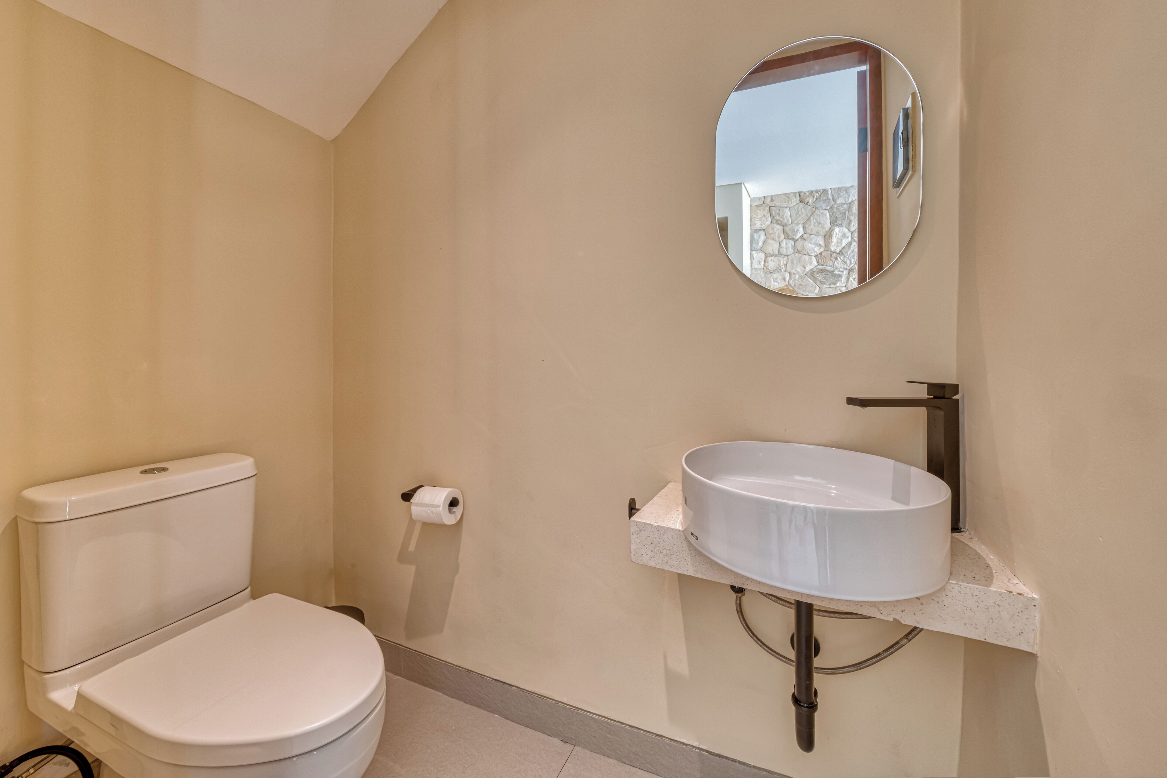 Een badkamer met een toilet, een wastafel en een spiegel.