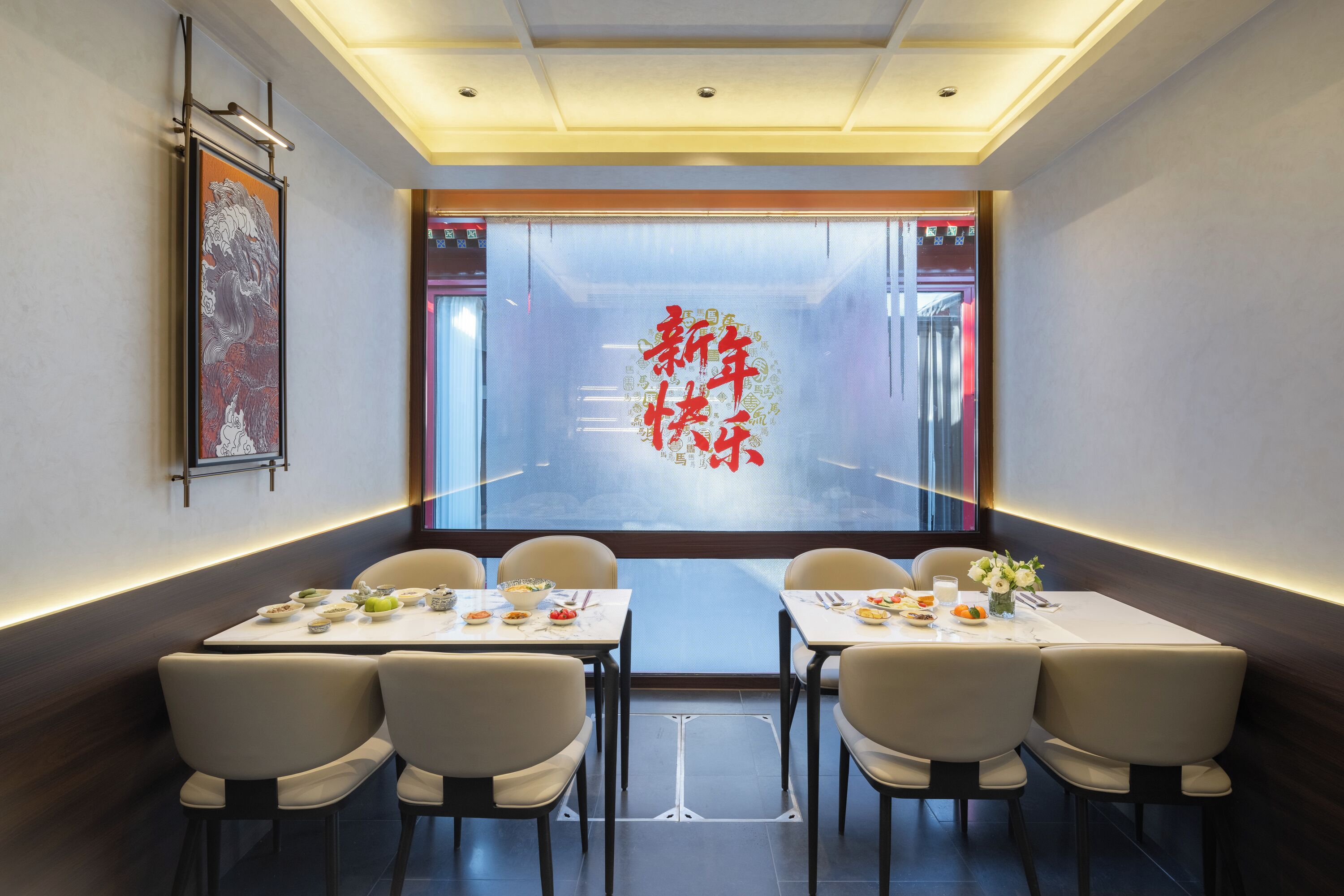 A dining area with tables set for four, chairs, and a large window with a decorative red design.