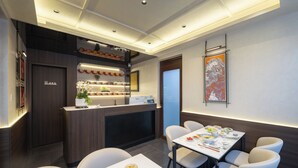 Un hall d’hôtel comprenant un comptoir d’accueil, un espace salon et une œuvre d’art accrochée au mur.
