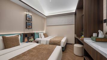 A hotel room with two beds, a vanity with a mirror, and a ceiling light.
