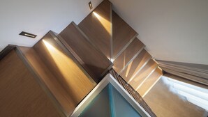 Un escalier moderne avec des marches en bois et un éclairage intégré.
