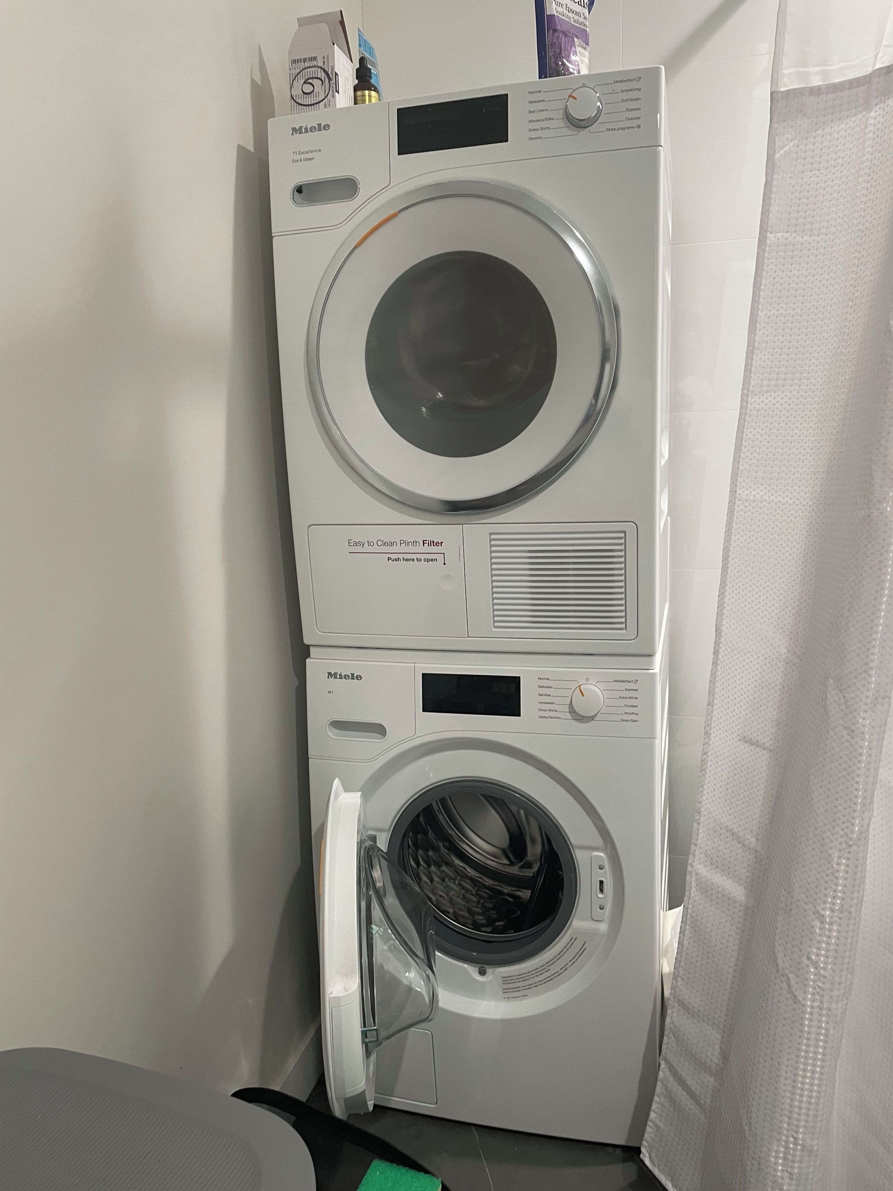 Máquina de lavar e secar empilhadas, com painel de controle, visor digital e botão para o filtro.