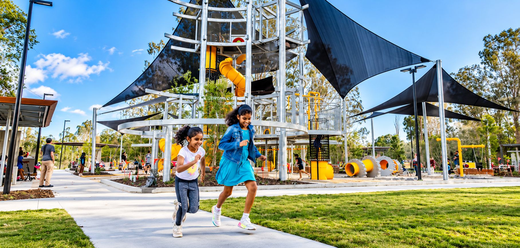 An outdoor playground with a climbing structure and slides, surrounded by a grassy area and trees.