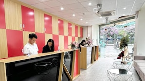 A reception area with a check-in counter, wooden lockers, and a view of the street outside. - HANOI CAPSULE STATION  (Hanoi)