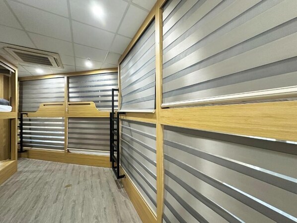 Une chambre avec un lit superposé, un bureau en bois et une porte coulissante.