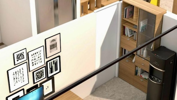 A modern interior with a staircase, framed artwork on the walls, and a wooden bookshelf. - HANOI CAPSULE STATION  (Hanoi)