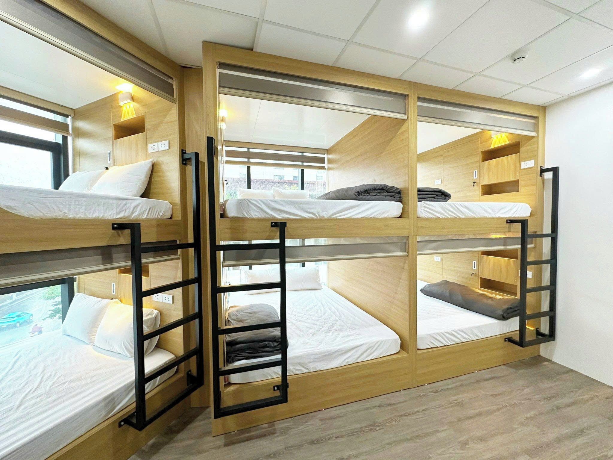 A bunk bed room with wooden frames and white bedding.