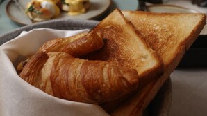 Un desayuno con cruasanes y pan tostado.