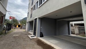 En bygning med flere etager, en flad facade, store vinduer og belagt grund.