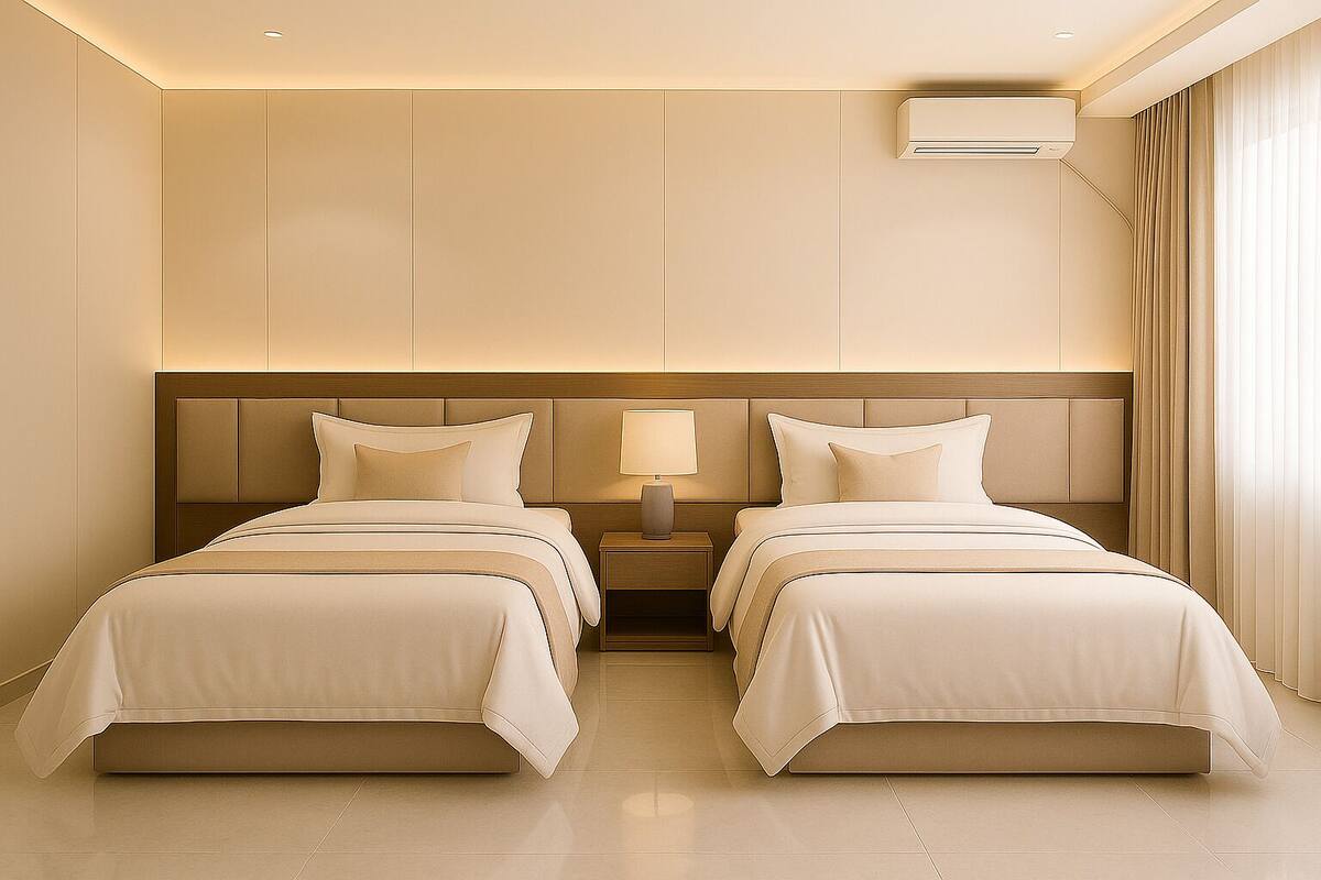 A hotel room with two beds, a nightstand with a lamp, an air conditioning unit, and a large window with curtains.