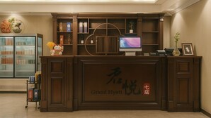 A reception desk with a digital screen, a glass display case, and a decorative vase. - JUN YUE VI Lagos hotel (Lagos)