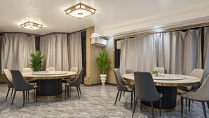 A modern dining area with two round tables, black and grey chairs, and a marble floor. - JUN YUE VI Lagos hotel (Lagos)
