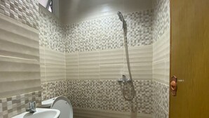 Un bagno con il water, lavandino e doccia.