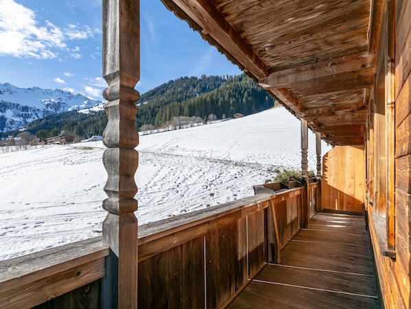 A wooden balcony with a view of a snowy landscape and mountains. - Two holiday apartments in farmhouse with a view (Alpbach)