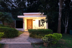 A modern house with a wooden door, a small porch, and a pathway leading to the entrance. - Thapovan Resort by Z Vacations (Kodaikanal)